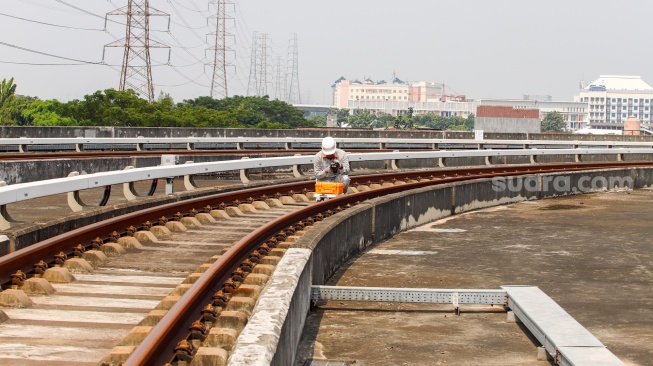 Pekerja melakukan pengecekan jalur Light Rail Transit (LRT) Jakarta di Depo LRT Jakarta Pegangsaan Dua, Jakarta, Rabu (8/5/2024). [Suara.com/Alfian Winanto]