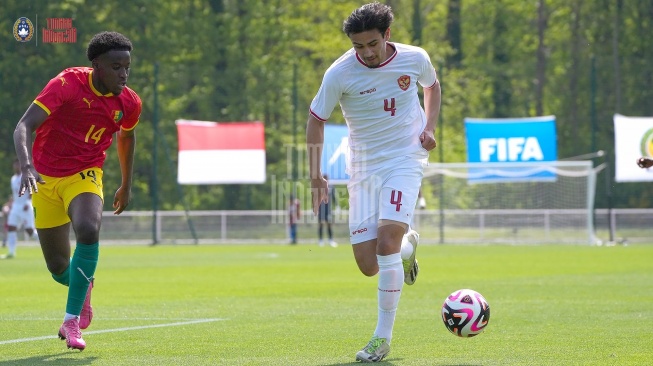 Bek Timnas Indonesia U-23, Nathan Tjoe-A-On menggiring bola diikuti pemain Guinea dalam laga playoff Olimpiade 2024 di INF Clairefontaine, Paris, Prancis, Kamis (9/5/2024) malam WIB. [Dok. PSSI]