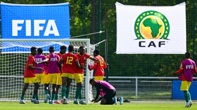 Para pemain Guinea merayakan kemenangan mereka di akhir pertandingan play-off pra-Olimpiade antara Indonesia dan Guinea di Clairefontaine-en-Yvelines, selatan Paris, Prancis, Kamis (9/5/2024) [MIGUEL MEDINA / AFP]