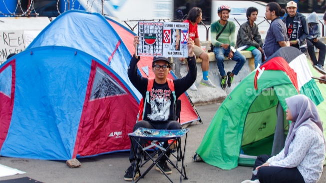 Sejumlah massa melakukan aksi di dekat tenda saat aksi solidaritas untuk Palestina di depan Kedutaan Besar Amerika untuk Indonesia, Jakarta, Jumat (10/5/2024). [Suara.com/Alfian Winanto]
