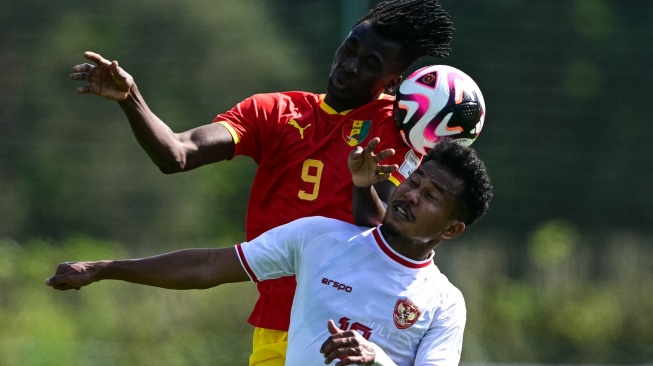 Penyerang Guinea Momo Fanye Toure (Kiri) berebut bola dengan bek Indonesi Bagas Kaffa selama pertandingan play-off pra-Olimpiade antara Indonesia dan Guinea di Clairefontaine-en-Yvelines, selatan Paris, Prancis, Kamis (9/5/2024). [MIGUEL MEDINA / AFP]
