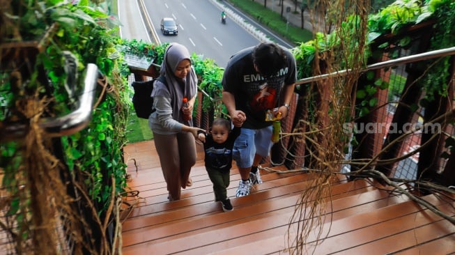 Warga mengunjungi Jembatan Penyebrangan Orang (JPO) Pinisi di Jalan Jenderal Sudirman, Jakarta, Jumat (10/5/2024). [Suara.com/Alfian Winanto]