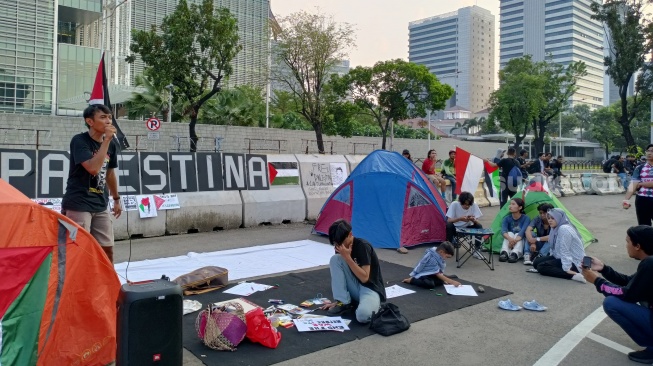 Penampakan para pendemo mendirikan tenda saat Aksi demo Bela Palestina di depan kantor Kedubes Amerika Serika di Jakarta. (Suara.com/Dea)