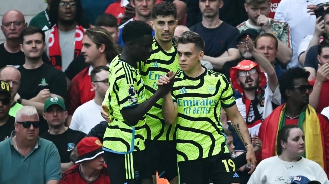 Para pemain Arsenal merayakan gol Leandro Trossard (kanan) pada laga Liga Inggris di Old Trafford, Manchester, Minggu (12/5/2024) malam WIB. [Paul ELLIS / AFP]