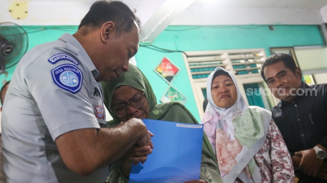 Petugas memberikan santunan secara simbolis kepada ahli waris korban kecelakaan bus di SMK Lingga Kencana, Depok, Jawa Barat, Senin (13/5/2024). [Suara.com/Alfian Winanto]