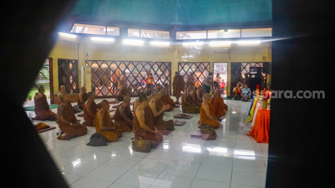 Para Bhikkhu berdoa saat tiba di Taman Mini Indonesia Indah, Jakarta, Selasa (14/5/2024). [Suara.com/Alfian Winanto]