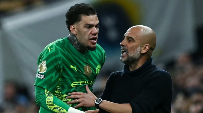 Kiper Manchester City, Ederson (kiri) berdebat dengan manajer Pep Guardiola menyusul keputusan sang juru taktik untuk menggantinya selama pertandingan tunda pekan ke-34 Liga Inggris 2023-2024 antara Tottenham Hotspur vs Manchester City di Stadion Tottenham Hotspur di London, pada 14 Mei 2024.Ben Stansall/AFP.