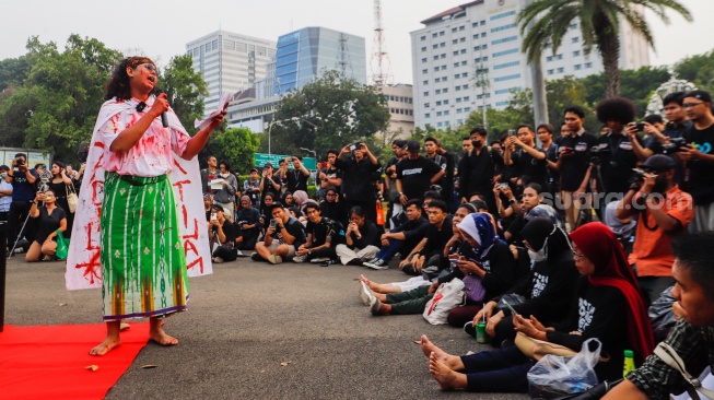 Sejumlah mahasiswa dari Sekolah Tinggi Filsafat Driyarkara menampilkan teaterikal pada Aksi Kamisan ke-815 di sebrang Istana Negara, Jakarta, Kamis (16/5/2024). [Suara.com/Alfian Winanto]