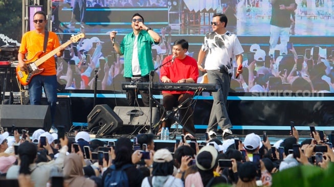 Grup musik Kahitna tampil menghibur warga saat Hari Bebas Kendaraan Bermotor (HBKB) di Bundaran HI, Jakarta, Minggu (19/5/2024). [Suara.com/Alfian Winanto]