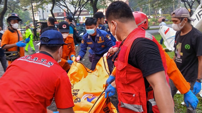 Petugas BPBD Kota Tangsel mengevakuasi jenazah korban pesawat jatuh di BSD Serpong, Tangerang Selatan, Banten, Minggu (18/5/2024). [ANTARA FOTO/Rais Fauzan Azhar/Bal/YU]