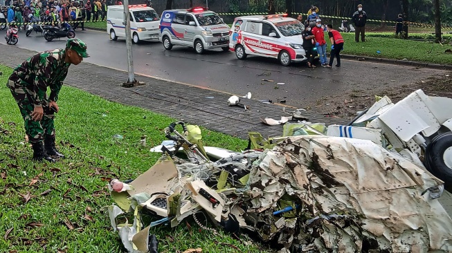 Petugas menyaksikan puing-puing pesawat yang jatuh di BSD Serpong, Tangerang Selatan, Banten, Minggu (18/5/2024). [ANTARA FOTO/Rais Fauzan Azhar/Bal/YU]