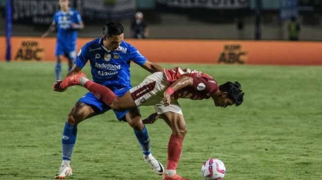 Pesepak bola Persib Bandung Ezra Walian (kiri) berebut bola dengan pesepak bola Bali United Kadek Agung (kanan) saat pertandingan semifinal Championship Series-BRI Liga 1 di Stadion Si Jalak Harupat, Kabupaten Bandung, Jawa Barat, Sabtu (18/5/2024). Persib berhasil mengalahkan Bali United dengan skor akhir 3-0. ANTARA FOTO/Novrian Arbi/foc. (ANTARA FOTO/NOVRIAN ARBI)