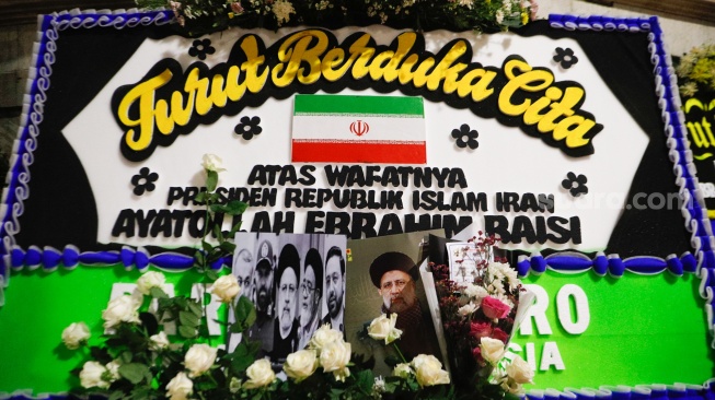 Karangan bunga yang dihiasi dengan foto Presiden Iran Ebrahim Raisi terpajang di depan Kantor Kedutaan Besar Iran, Jakarta, Senin (20/5/2024). [Suara.com/Alfian Winanto]