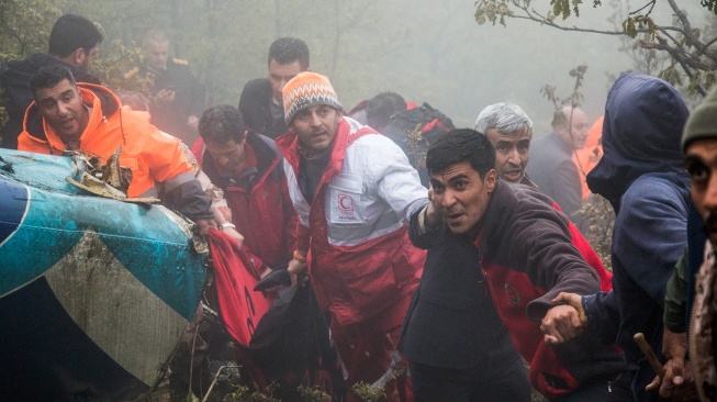 Tim penyelamat mengevakuasi jenazah di lokasi jatuhnya helikopter yang mengangkut Presiden Iran di daerah pegunungan Varzaghan di barat laut Iran, Senin (20/5/2024). [Azin HAGHIGHI / MOJ News Agency / AFP]