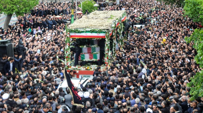 Orang-orang berpartisipasi dalam prosesi pemakaman Presiden Iran Ebrahim Raisi dan korban lainnya di Tabriz, Provinsi Azerbaijan Timur, Selasa (21/5/2024).  [AZIN HAGHIGHI / MOJ News Agency / AFP]