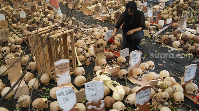 Aktivis hak asasi manusia (HAM) menabur bunga di instalasi Peringatan 26 Tahun Reformasi di kawasan Menteng, Jakarta Pusat, Selasa (21/5/2024). [Suara.com/Alfian Winanto]