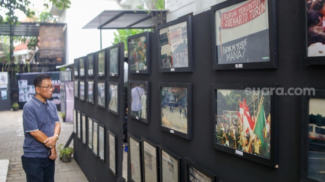 Aktivis hak asasi manusia (HAM) melihat pameran foto Peringatan 26 Tahun Reformasi di kawasan Menteng, Jakarta Pusat, Selasa (21/5/2024). [Suara.com/Alfian Winanto]