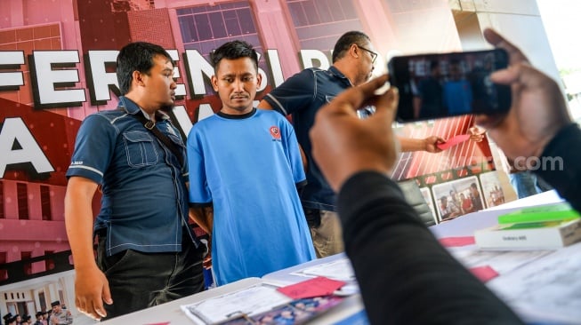 Petugas Kepolisian menggiring tersangka kasus pembunuhan Pegi Setiawan untuk dihadirkan pada konferensi pers yang digelar di Gedung Ditreskrimum Polda Jabar, Bandung, Jawa Barat, Minggu (26/5/2024). [ANTARA FOTO/Raisan Al Farisi/foc]