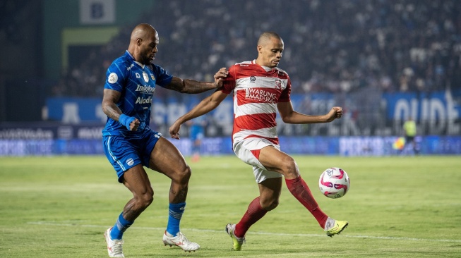 Pesepak bola Persib Bandung David da Silva (kiri) berusaha merebut bola dari pesepak bola Madura United Cleberson (kanan) saat pertandingan leg pertama final Championship Series-BRI Liga 1 di Stadion Si Jalak Harupat, Kabupaten Bandung, Jawa Barat, Minggu (26/5/2024). ANTARA FOTO/M Agung Rajasa/rwa.