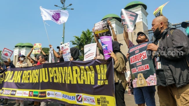 Sejumlah wartawan menggelar aksi menolak rancangan undang-undang (RUU) penyiaran di depan Gedung DPR, Senayan, Jakarta, Senin (27/5/2024). [Suara.com/Alfian Winanto]
