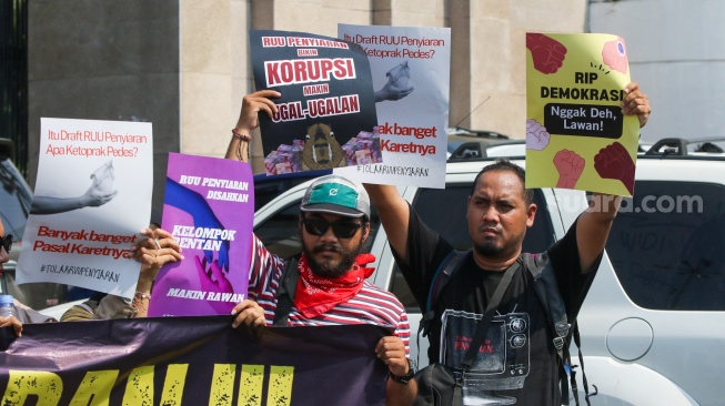 Sejumlah wartawan menggelar aksi menolak rancangan undang-undang (RUU) penyiaran di depan Gedung DPR, Senayan, Jakarta, Senin (27/5/2024). [Suara.com/Alfian Winanto]
