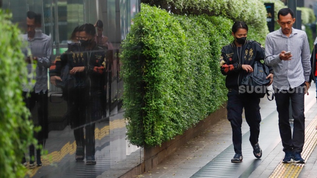 Pekerja melintas di kawasan Perkantoran Sudirman, Jakarta, Selasa (28/5/2024). [Suara.com/Alfian Winanto]