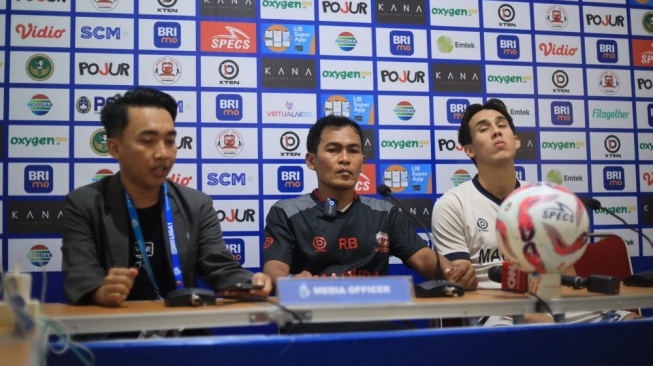 Caretaker Madura United Rakhmat Basuki (tengah) dan salah satu pemainnya Jacob Mahler (kanan) hadiri jumpa pers jelang leg kedua final Championship Series BRI Liga 1 kontra Persib Bandung. [Dok. Liga Indonesia Baru]