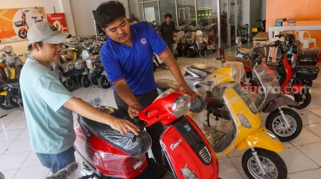 Petugas mengecek kendaraan bermotor listrik di Jatinegara, Jakarta, Kamis (30/5/2024). [Suara.com/Alfian Winanto]