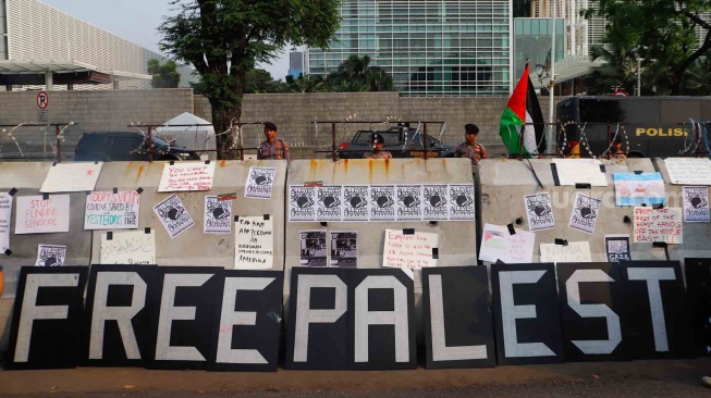 Sejumlah poster terpasang di barier saat aksi solidaritas untuk Palestina di depan Kedutaan Besar Amerika untuk Indonesia, Jakarta, Jumat (31/5/2024). [Suara.com/Alfian Winanto]