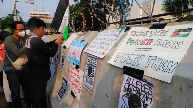 Sejumlah poster terpasang di barier saat aksi solidaritas untuk Palestina di depan Kedutaan Besar Amerika untuk Indonesia, Jakarta, Jumat (31/5/2024). [Suara.com/Alfian Winanto]