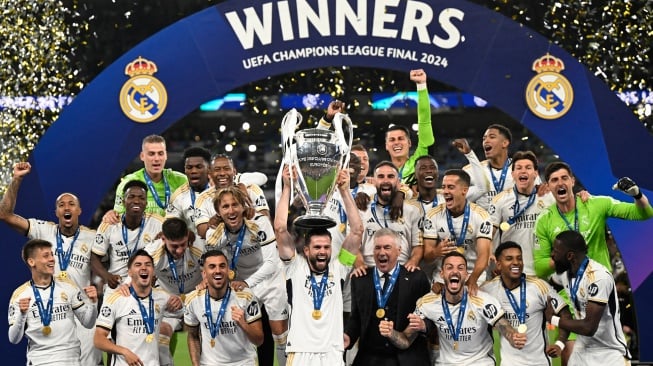 Bek Real Madrid Nacho Fernandez (tengah) dan para pemain Real Madrid mengangkat trofi untuk merayakan kemenangan mereka di akhir pertandingan sepak bola final Liga Champions 2023/2024 antara Real Madrid melawan Borussia Dortmund di Stadion Wembley, London, Inggris, Sabtu (1/6/2024). [INA FASSBENDER / AFP]