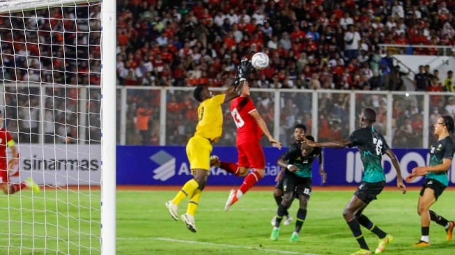 Bek Timnas Indonesia Muhammad Ferrari berebut bola atas dengan kiper Tanzania saat pertandingan Friendly Match antara Indonesia melawan Tanzania di Stadion Madya, Jakarta, Minggu (2/6/2024). [Suara.com/Alfian Winanto]