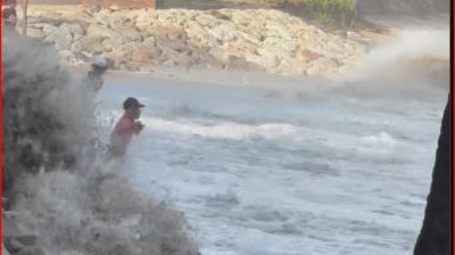 Bagaikan Aang, Bapak-bapak Ini Malah Menyambut Ombak Pasang di Pantai Kuta