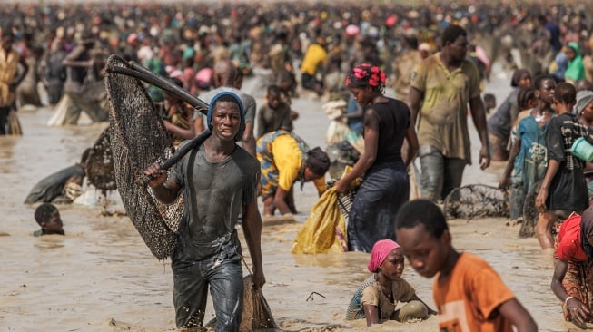 Seorang pemuda membawa jaring ikannya saat mengikuti ritual penangkapan ikan Sanke Mon di San, Wilayah Sego, Mali, Kamis (6/6/2024). [OUSMANE MAKAVELI / AFP] 