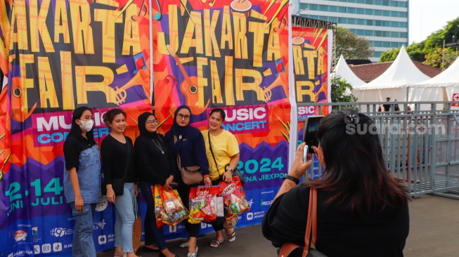 Pengunjung berswafoto di area Jakarta Fair 2024 di JIExpo Kemayoran, Jakarta, Kamis (13/6/2024). [Suara.com/Alfian Winanto]