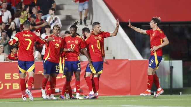 Gelandang Spanyol Pedri merayakan bersama rekan satu timnya setelah mencetak gol pertama timnya selama pertandingan sepak bola persahabatan internasional antara Spanyol dan Irlandia Utara di stadion Son Moix di Palma de Mallorca pada 8 Juni 2024.JAIME REINA / AFP
