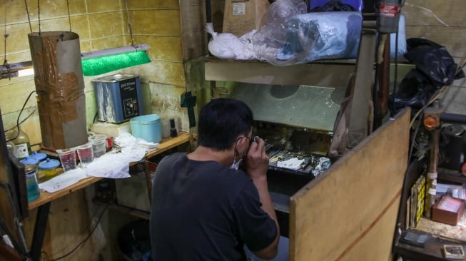 Perajin menyelesaikan pembuatan cincin di Metro Pasar Baru, Jakarta Pusat, Jumat (14/6/2024). [Suara.com/Alfian Winanto]