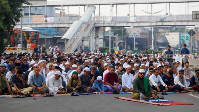 Umat muslim melaksanakan Salat Idul Adha berjemaah di Terminal Kampung Melayu, Jakarta, Senin (17/6/2024). [Suara.com/Alfian Winanto]