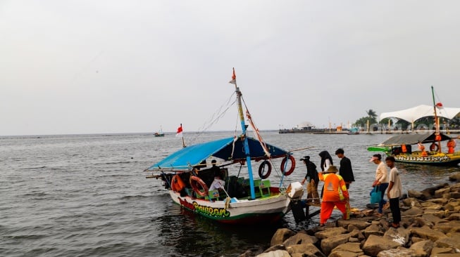 Pengunjung berwisata di Pantai Lagoon, Ancol Taman Impian, Jakarta, Selasa (18/6/2024). [Suara.com/Alfian Winanto]