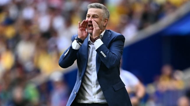 Gestur pelatih Timnas Rumania, Edward Iordanescu saat memimpin timnya di pertandingan Euro 2024. [Fabrice COFFRINI / AFP]