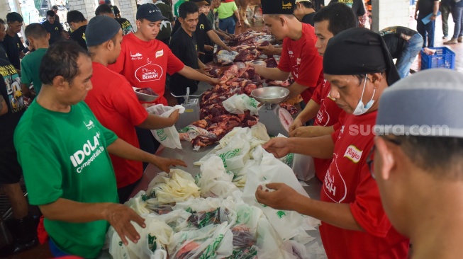 Sejumlah petugas memotong daging hewan kurban di halaman Masjid Istiqlal, Jakarta, Selasa (18/6/2024). [Suara.com/Alfian Winanto]