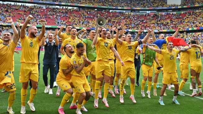 Timnas Rumania merayakan kemenangan atas Ukraina pada pertandingan Euro 2024 di Allianz Arena, Munich, Jerman, Senin (17/6/2024) malam WIB. [MIGUEL MEDINA / AFP]