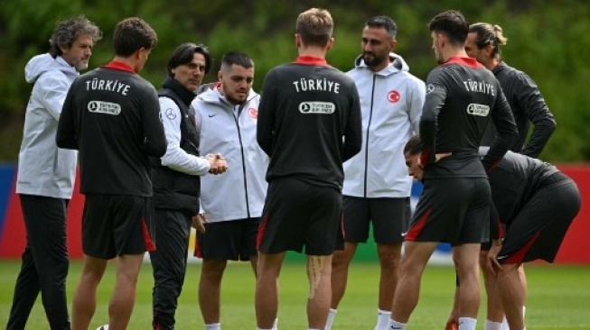 Pelatih kepala Turki asal Italia Vincenzo Montella (ketiga dari kiri) berbicara dengan para pemain Turki selama sesi latihan tim menjelang Euro 2024 di base camp tim di Barsinghausen pada 13 Juni 2024. OZAN KOSE / AFP