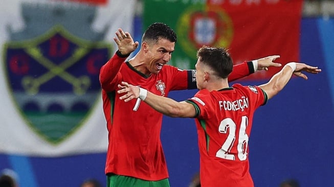 Penyerang timnas Portugal, Cristiano Ronaldo dan pencetak Francisco Conceicao melakukan selebrasi di lapangan setelah pertandingan Grup F UEFA Euro 2024 antara Portugal vs Republik Ceko di Stadion Leipzig di Leipzig pada 18 Juni 2024.Adrian DENNIS / AFP.