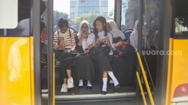 Sejumlah pelajar menaiki Bus Sekolah di kawasan Pasar Baru, Jakarta, Rabu (19/6/2024). [Suara.com/Alfian Winanto]