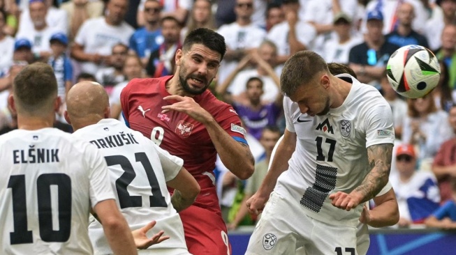 Penyerang timnas Serbia, Aleksandar Mitrovic dan penyerang Slovenia, Jan Mlakar berebut bola pada pertandingan kedua Grup C Euro 2024 antara Slovenia vs Serbia di Munich Football Arena di Munich, Jerman selatan, pada 20 Juni 2024.DAMIEN MEYER / AFP.