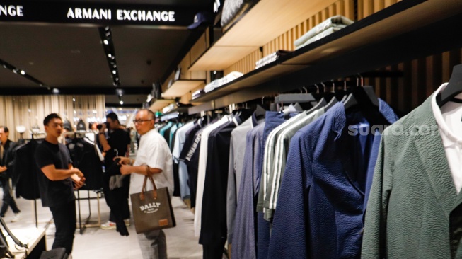 Pengunjung memilih pakaian saat pembukaan Armani Exchange Store Indonesia di Grand Indonesia, Jakarta, Rabu (26/6/2024). [Suara.com/Alfian Winanto]