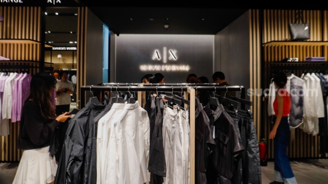 Pengunjung memilih pakaian saat pembukaan Armani Exchange Store Indonesia di Grand Indonesia, Jakarta, Rabu (26/6/2024). [Suara.com/Alfian Winanto]