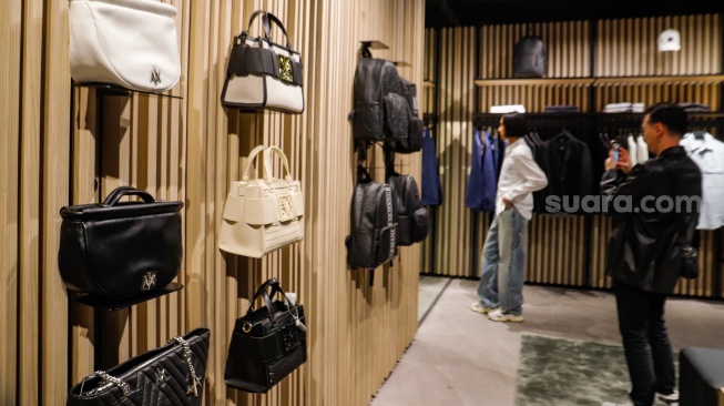 Pengunjung memilih pakaian saat pembukaan Armani Exchange Store Indonesia di Grand Indonesia, Jakarta, Rabu (26/6/2024). [Suara.com/Alfian Winanto]