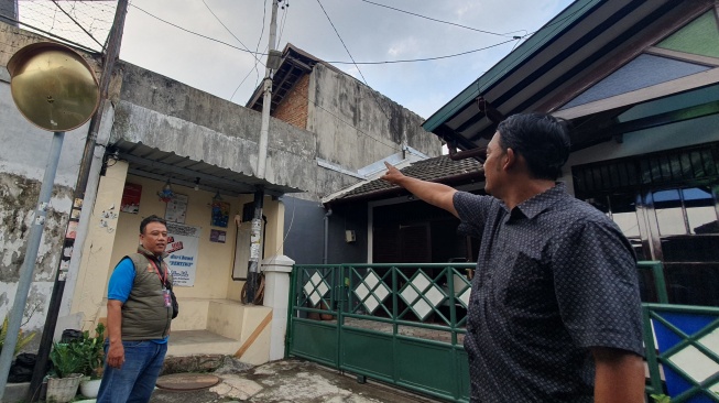 Bekti Pranoto Wulan (kanan) dan Elvin Sigit Prasetyo (kiri) menunjukkan tembok belakang SMPN 6 Yogyakarta. [Hiskia Andika/Suarajogja.id]